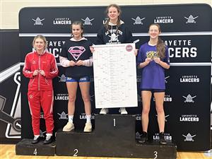Four girls stand on a black podium displaying their medals. Fox's wrestler stands on number 4. 